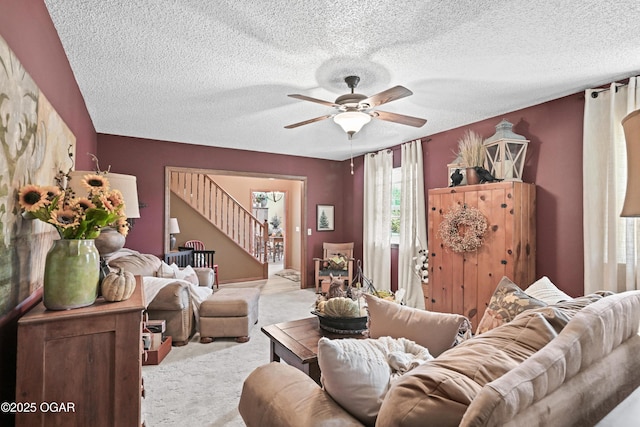 carpeted living room with stairway, a textured ceiling, and ceiling fan