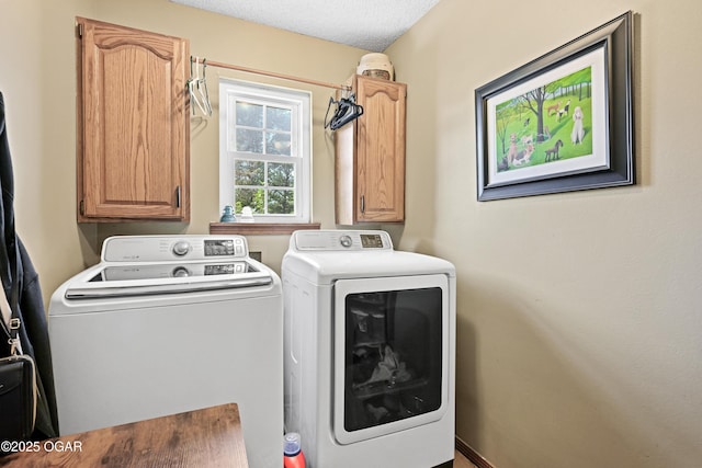 clothes washing area featuring cabinet space, washer and dryer, and a textured ceiling