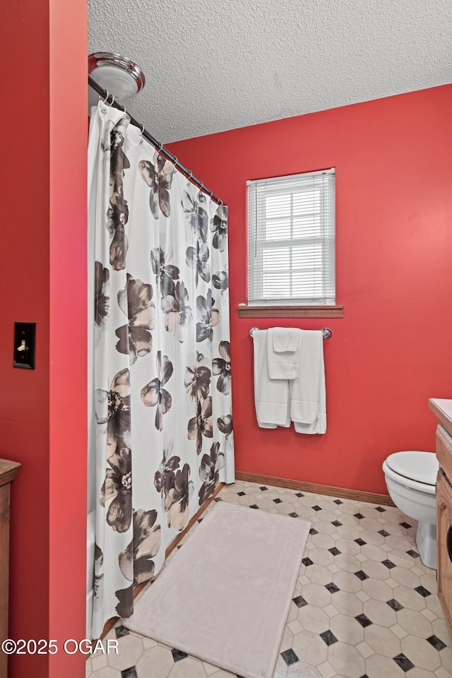 full bathroom with vanity, a shower with curtain, baseboards, a textured ceiling, and toilet