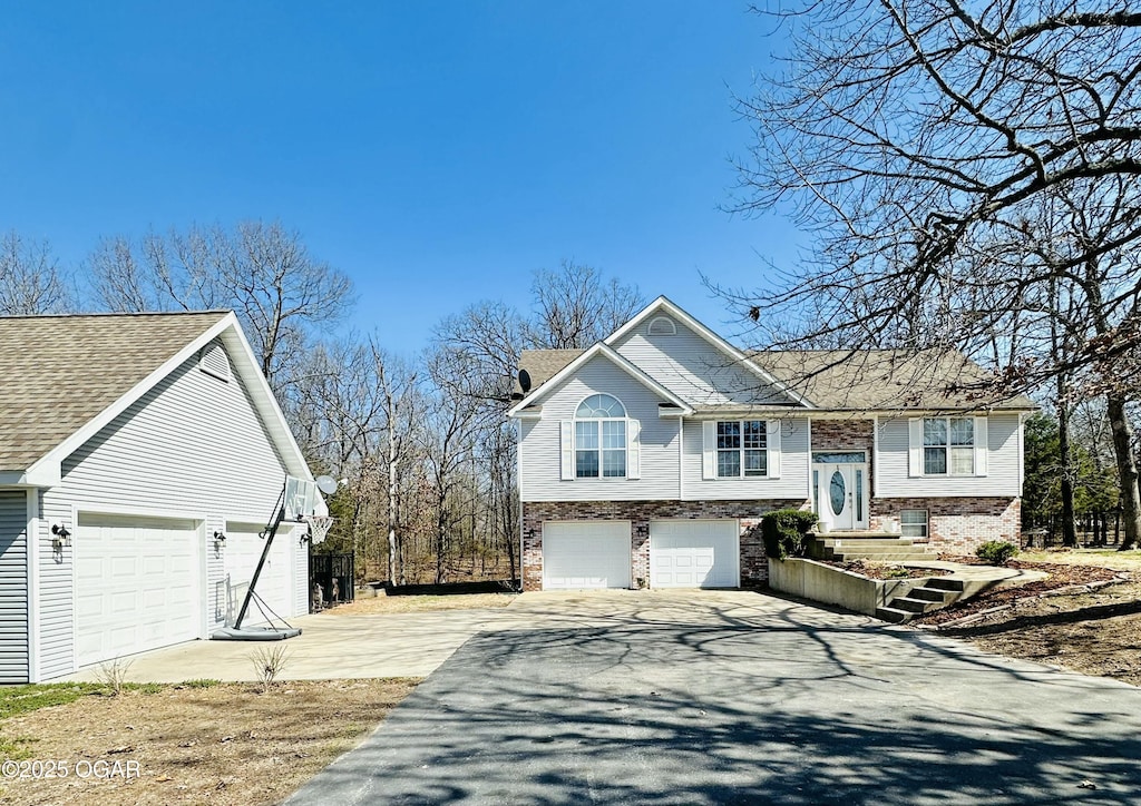 raised ranch with aphalt driveway and brick siding