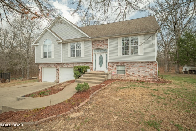 bi-level home featuring a garage, brick siding, roof with shingles, and driveway