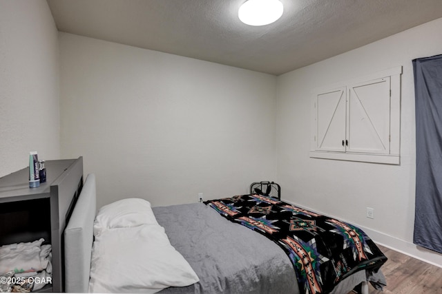 bedroom with wood finished floors and a textured ceiling