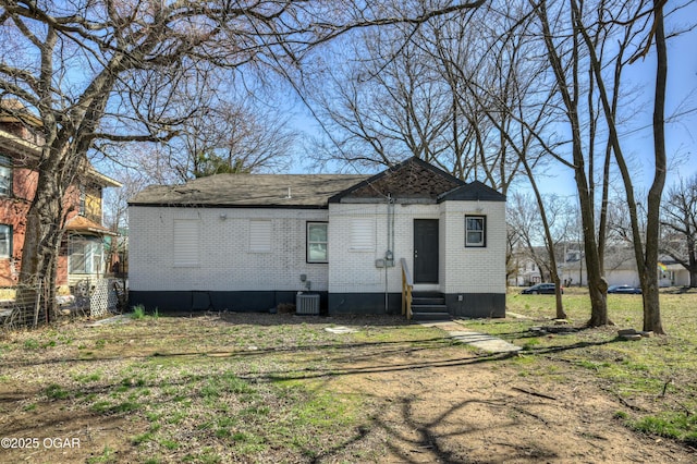 view of front facade featuring brick siding, central air condition unit, and entry steps