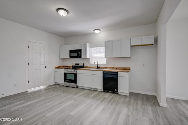 kitchen with black appliances, light wood-style floors, baseboards, and a sink