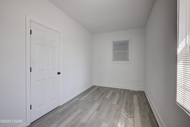 unfurnished room with light wood-style flooring and baseboards