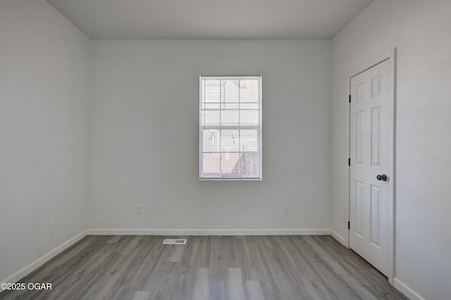 unfurnished bedroom with wood finished floors, visible vents, and baseboards