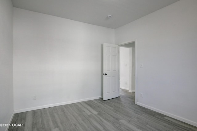 unfurnished room featuring baseboards and wood finished floors