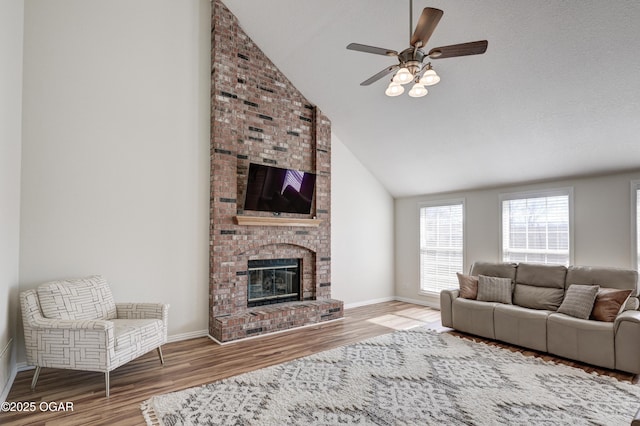 living area with wood finished floors, a fireplace, and baseboards