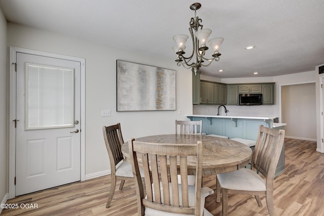 dining room featuring light wood finished floors, a chandelier, recessed lighting, and baseboards