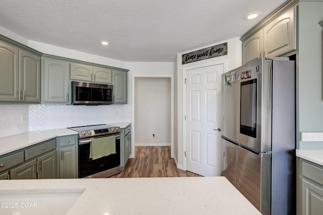 kitchen featuring tasteful backsplash, appliances with stainless steel finishes, and a textured ceiling