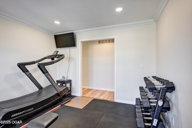 workout room featuring crown molding, baseboards, and visible vents