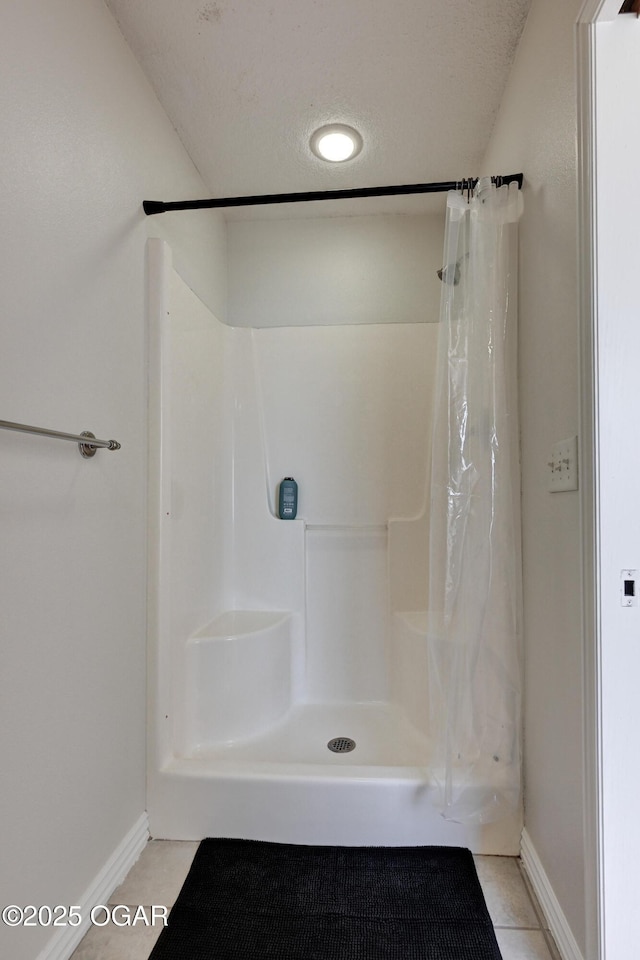 bathroom featuring tile patterned flooring, curtained shower, and a textured ceiling