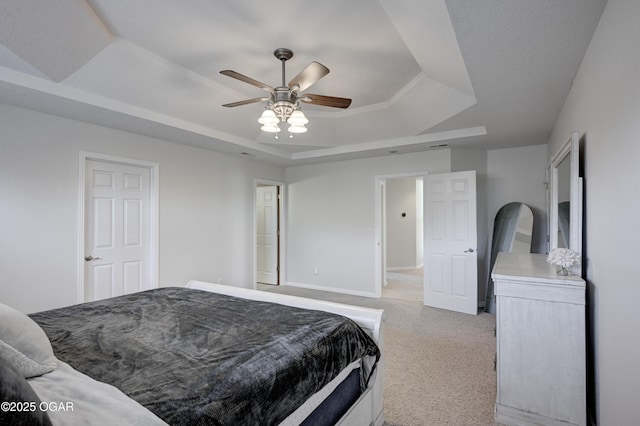 bedroom featuring a tray ceiling, baseboards, and a ceiling fan