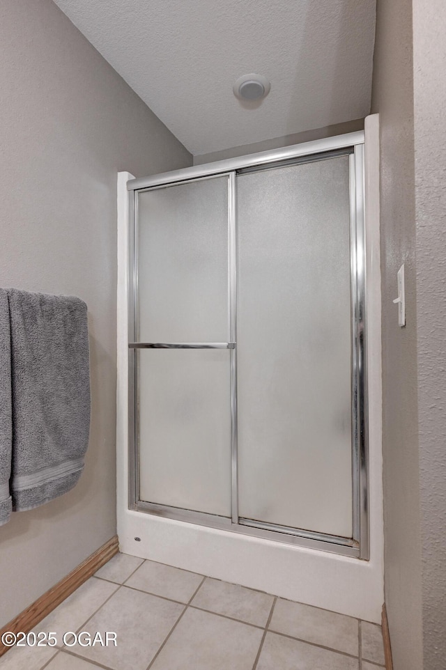 bathroom featuring tile patterned flooring and a shower stall