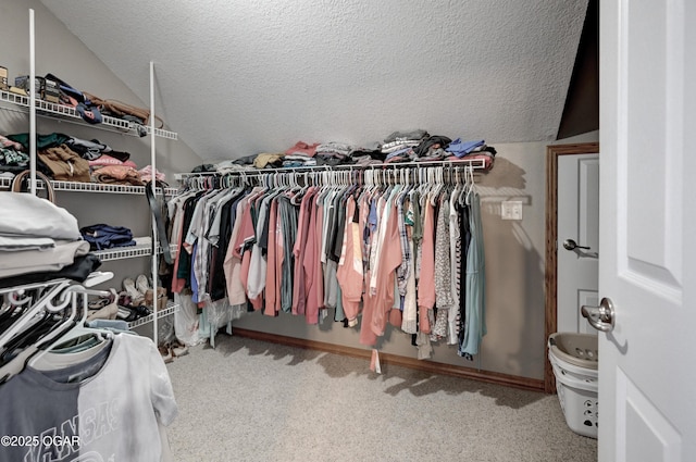 spacious closet with carpet floors and vaulted ceiling