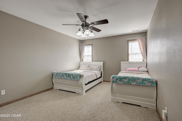 bedroom with carpet flooring, baseboards, visible vents, and a textured ceiling