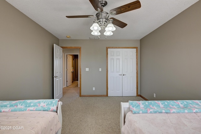 bedroom with visible vents, baseboards, carpet floors, a closet, and a ceiling fan