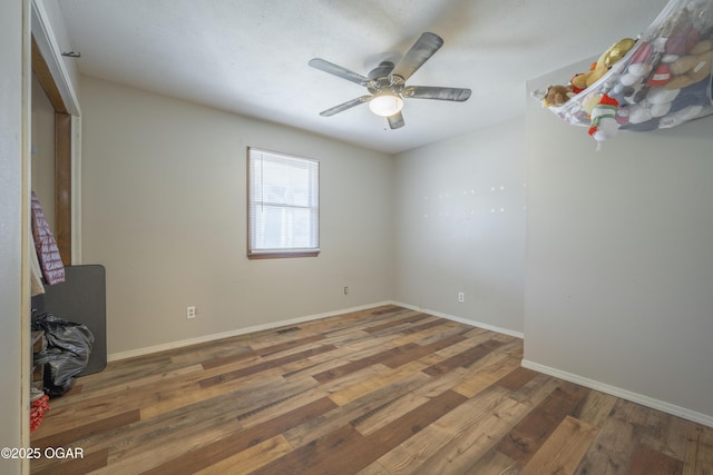 unfurnished bedroom with baseboards, wood finished floors, and a ceiling fan