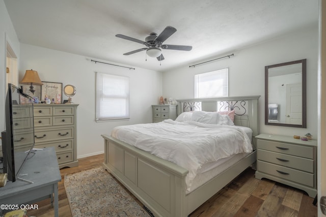 bedroom with a ceiling fan and dark wood-style flooring