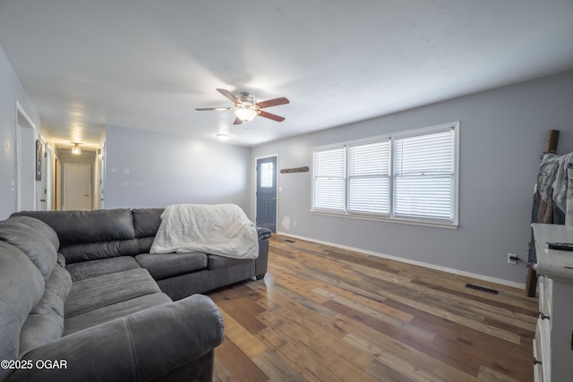 living room with visible vents, ceiling fan, baseboards, and hardwood / wood-style flooring