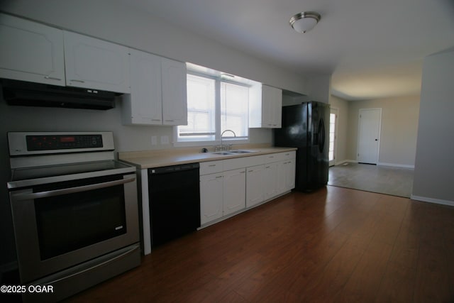 kitchen featuring black appliances, under cabinet range hood, a sink, light countertops, and dark wood-style flooring