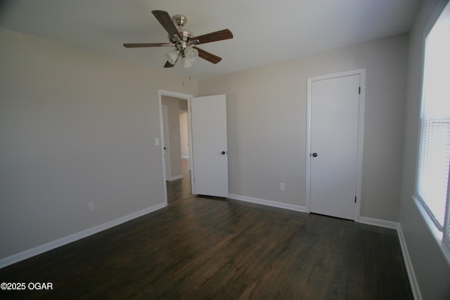 unfurnished bedroom featuring baseboards, ceiling fan, and dark wood-style flooring