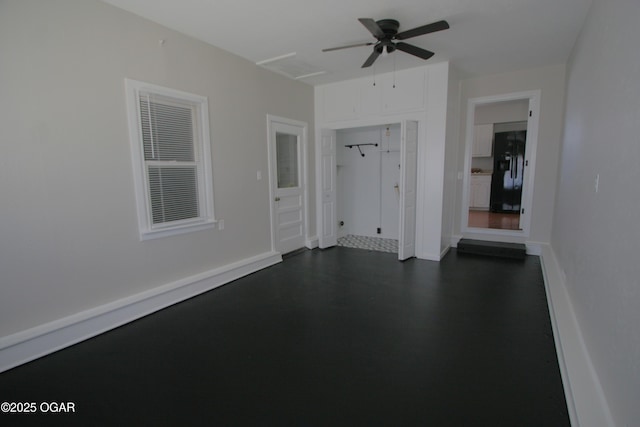 empty room featuring ceiling fan, dark wood-type flooring, and baseboards