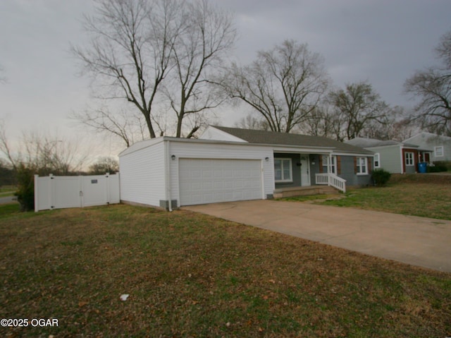 view of front facade featuring a gate, fence, concrete driveway, a front yard, and an attached garage