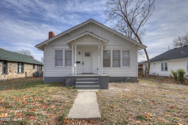 bungalow-style house featuring a chimney and central AC