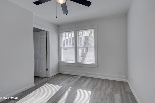 unfurnished room featuring visible vents, wood finished floors, baseboards, and ceiling fan