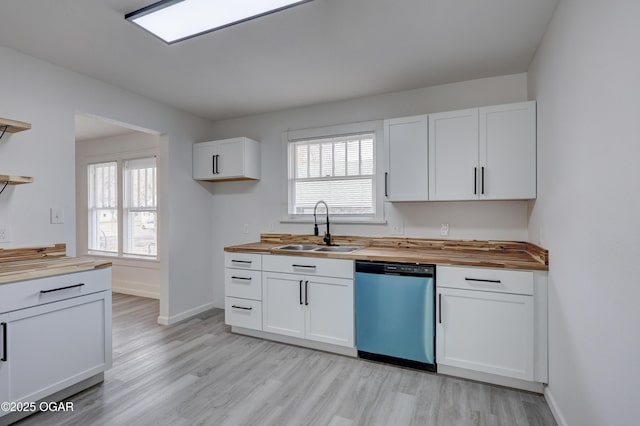 kitchen with white cabinetry, dishwasher, butcher block counters, and a sink