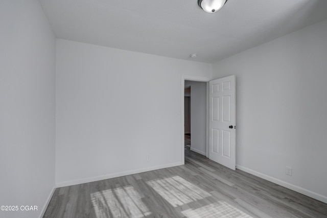 unfurnished room featuring baseboards and wood finished floors