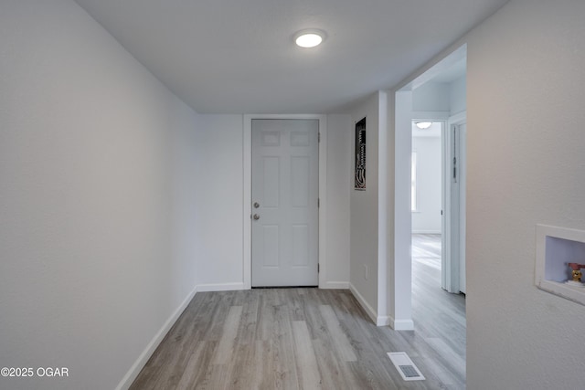 corridor with visible vents, baseboards, and wood finished floors