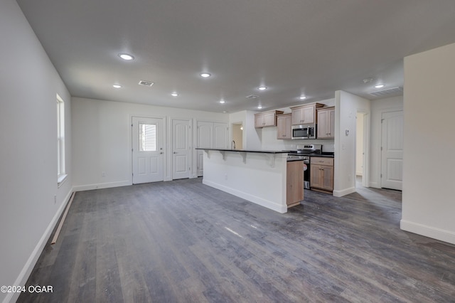 kitchen with visible vents, dark wood-type flooring, dark countertops, stainless steel appliances, and baseboards