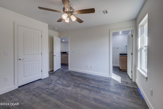 unfurnished bedroom with dark wood finished floors, baseboards, and visible vents