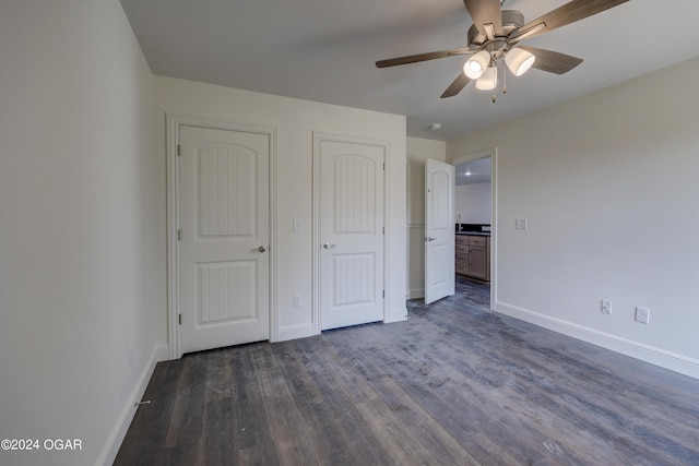 unfurnished bedroom featuring ceiling fan, baseboards, and dark wood-style floors