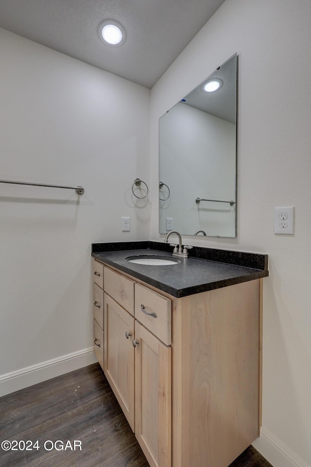 bathroom featuring vanity, baseboards, and wood finished floors