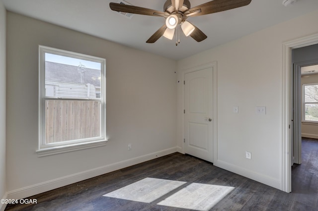 unfurnished bedroom with ceiling fan, baseboards, and dark wood finished floors