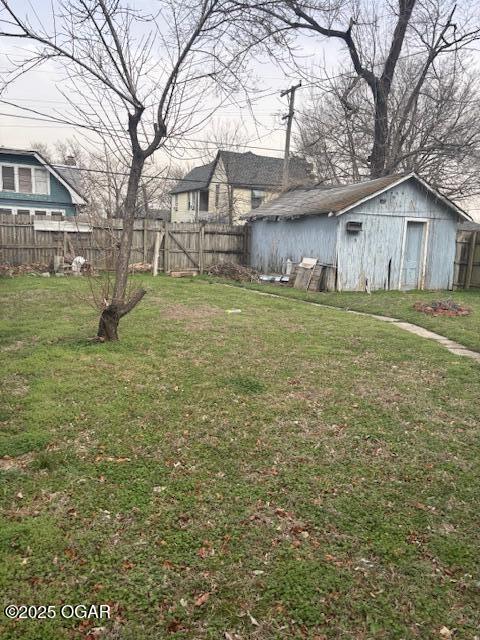 view of yard featuring an outbuilding and fence