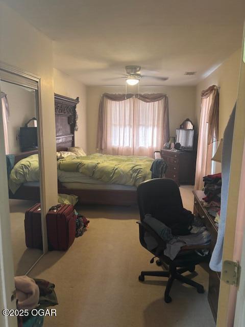 carpeted bedroom featuring visible vents and ceiling fan