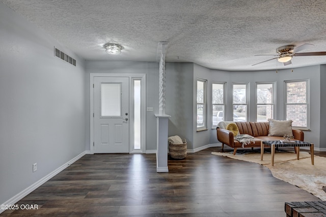 foyer with dark wood finished floors, visible vents, baseboards, and a ceiling fan