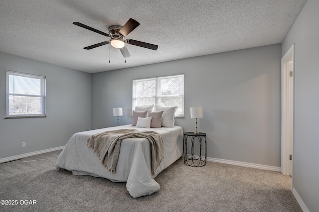 bedroom featuring multiple windows, carpet floors, baseboards, and a ceiling fan