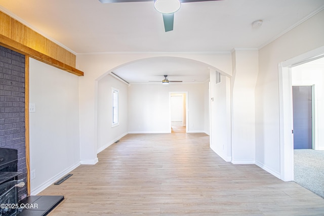 unfurnished room with visible vents, arched walkways, ceiling fan, and ornamental molding