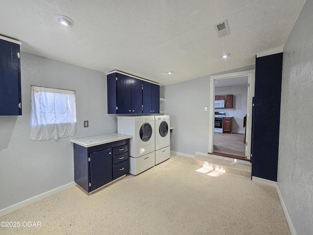 washroom featuring baseboards, visible vents, cabinet space, a textured ceiling, and washing machine and dryer