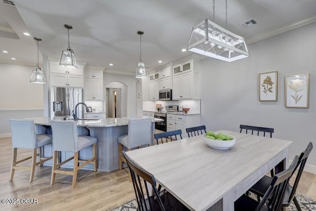 dining space with visible vents, ornamental molding, recessed lighting, light wood finished floors, and baseboards