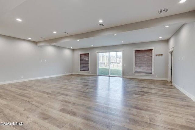 unfurnished living room with visible vents, baseboards, and light wood-style floors