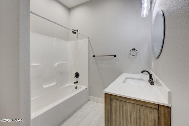 bathroom featuring vanity, tub / shower combination, and baseboards