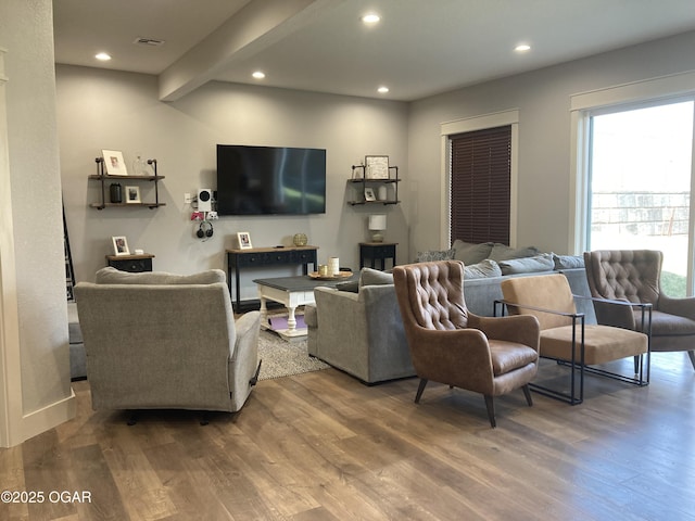 living room with beam ceiling, recessed lighting, wood finished floors, and visible vents