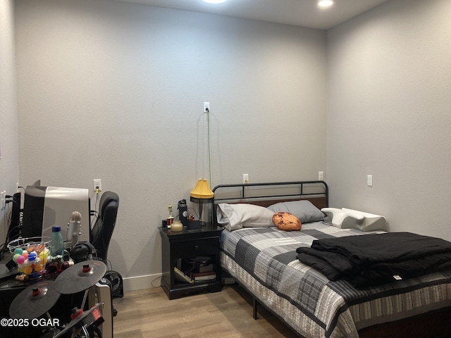 bedroom with baseboards and wood finished floors