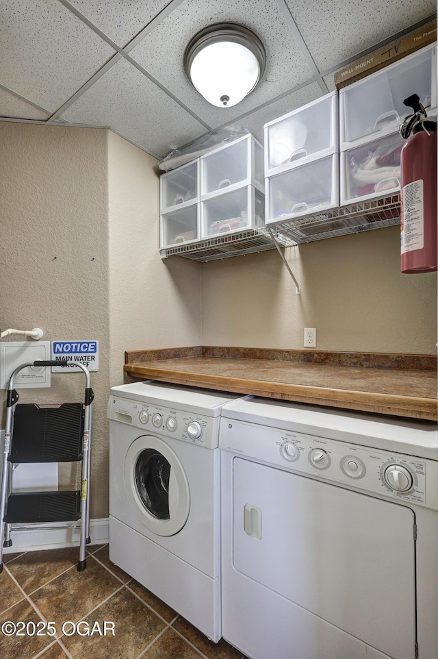 laundry area with laundry area, dark tile patterned flooring, and washer and clothes dryer